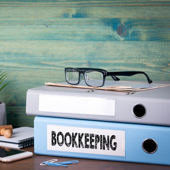 Bookkeeping folders with glasses sitting on top
