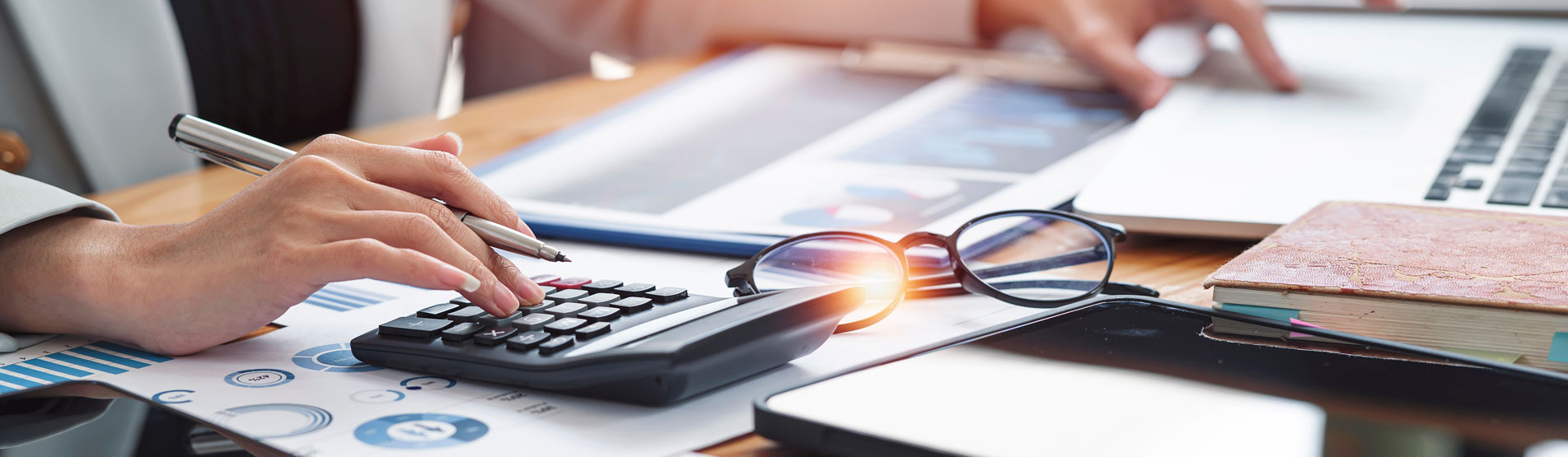 Businesswoman calculating taxes with calculator in sunlight