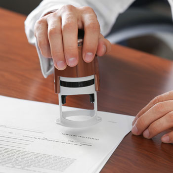 Notary using the tools of his trade on a document